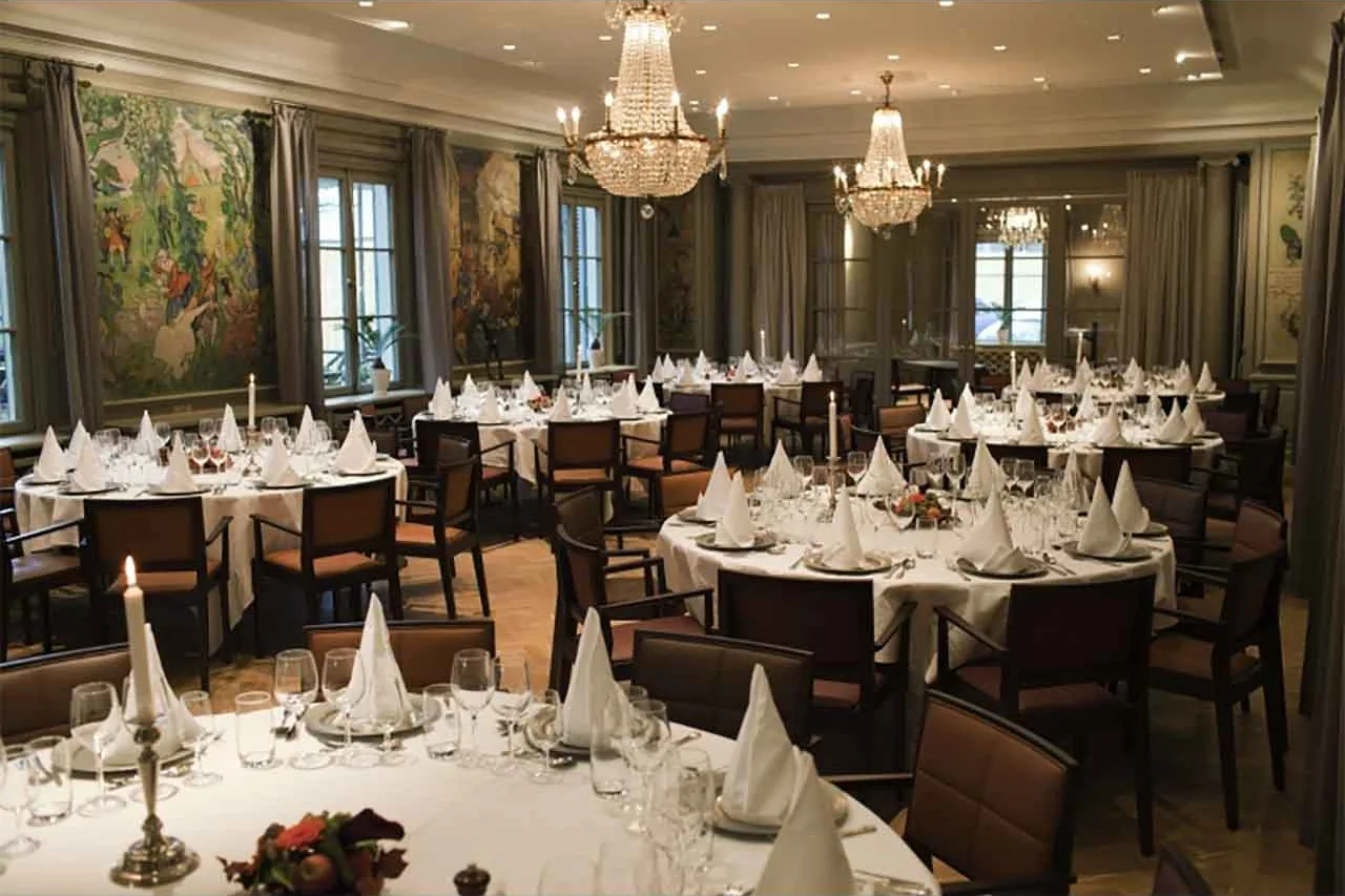 The dining rooms of Tingshuset at Stallmästaregården — chandeliers, set tables, and a grand piano